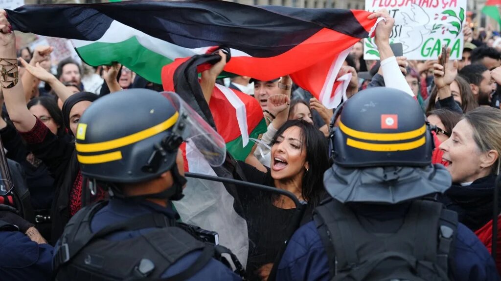 Protesters face riot police officers during a demonstration in support of Palestinians at the Place de la Republique, Paris, on 19 October 2023 (AFP)