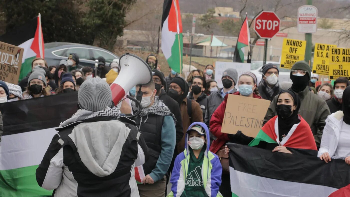 A protest organiser leads a crowd in a series of chants in front of the Israeli embassy in Washington
