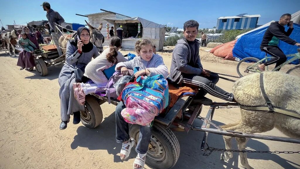 Palestinians set out to Khan Younis with their belongings, from Rafah's Tel al-Sultan area after it was encircled by Israeli forces on 23 March 2025 (AFP)