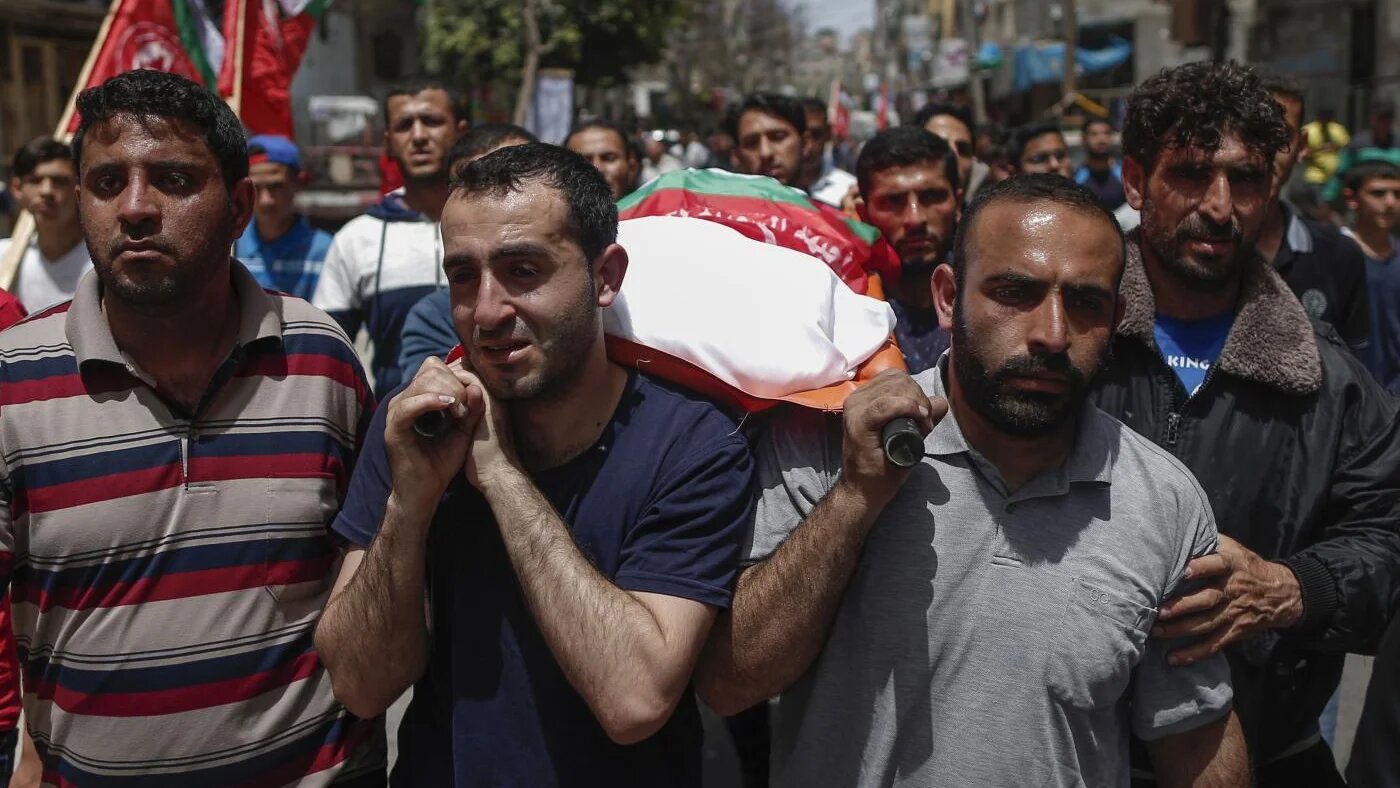 Relatives carry the body of a Palestinian, who was killed in Israeli strikes the previous day, during a funeral ceremony in Beit Lahia, in northern Gaza Strip (AFP)