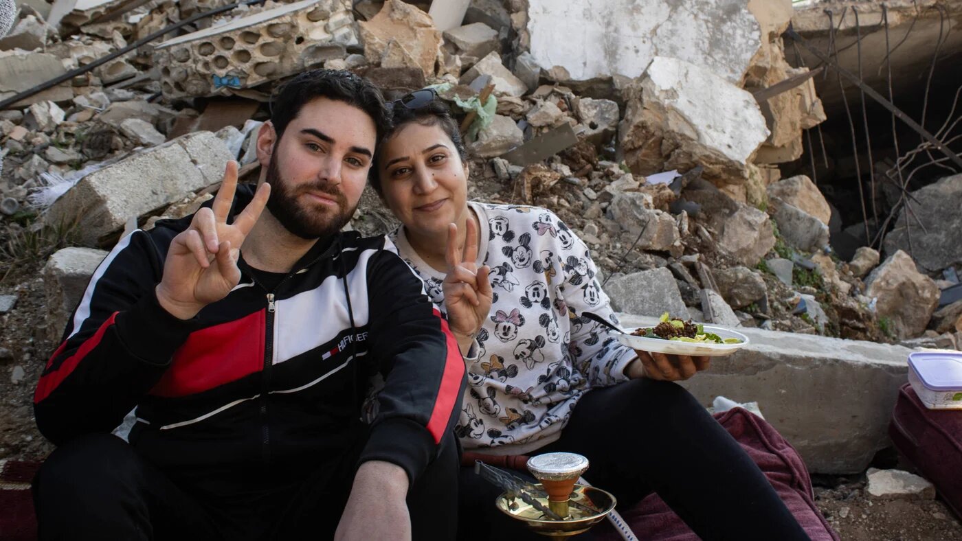 Sitting next to his neighbour Zainab Aqil, Ali Awad points to a pile of shattered cinder blocks behind him, saying: ‘This is my home and this is her home’ (Hanna Davis/MEE) 