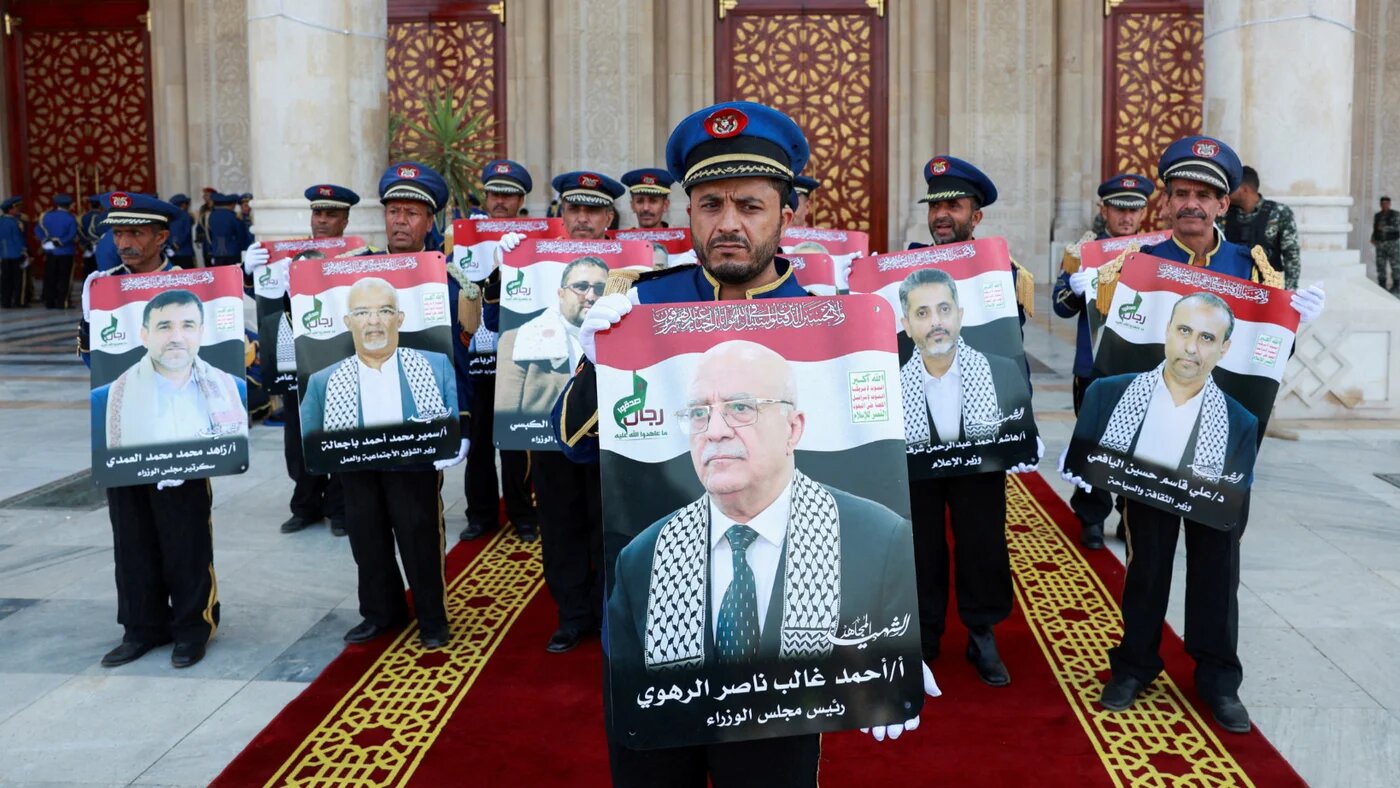 Honour guard hold photos of Prime Minister of Yemen's Houthi-led government Ahmed al-Rahwi and other officials killed in an Israeli strike, during a funeral procession in Sanaa, 1 September 2025 (Reuters)
