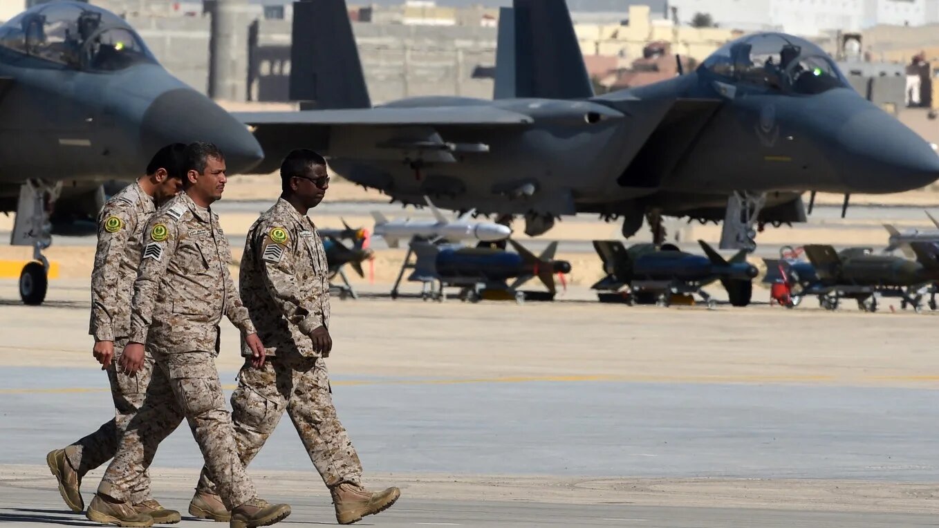 Saudi officers walk past F-15 fighter jets, GBU bombs and missiles at King Salman airbase in Riyadh on 25 January 2017.
