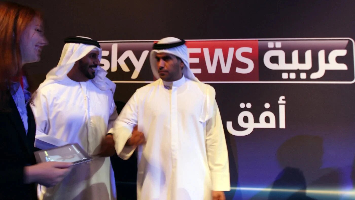Emiratis stand in front of the Sky News Arabia logo during the launch of the network in Abu Dhabi on 6 May 2012 (AFP/Marwan Naamani)