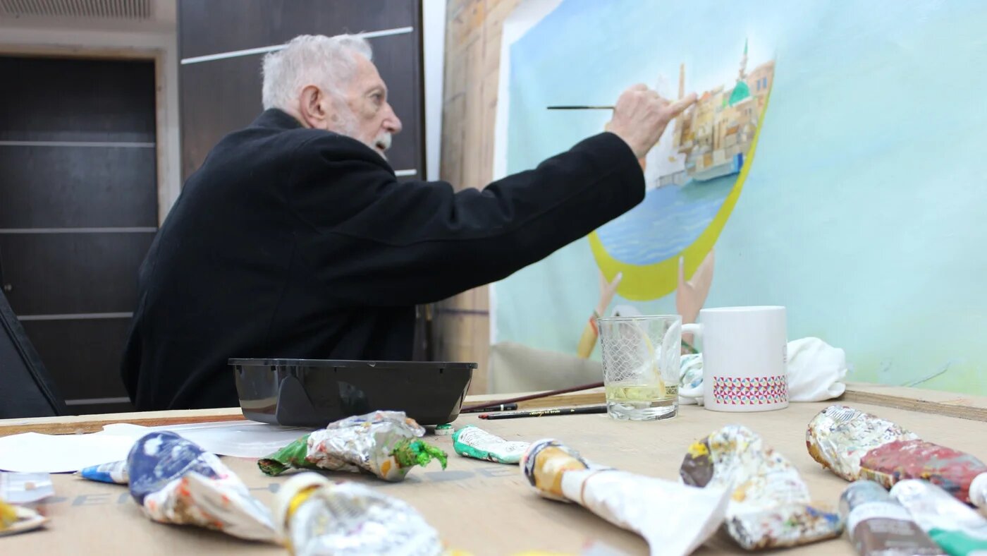 Mansour working on a painting at his workshop in Ramallah (Nadda Osman/MEE)