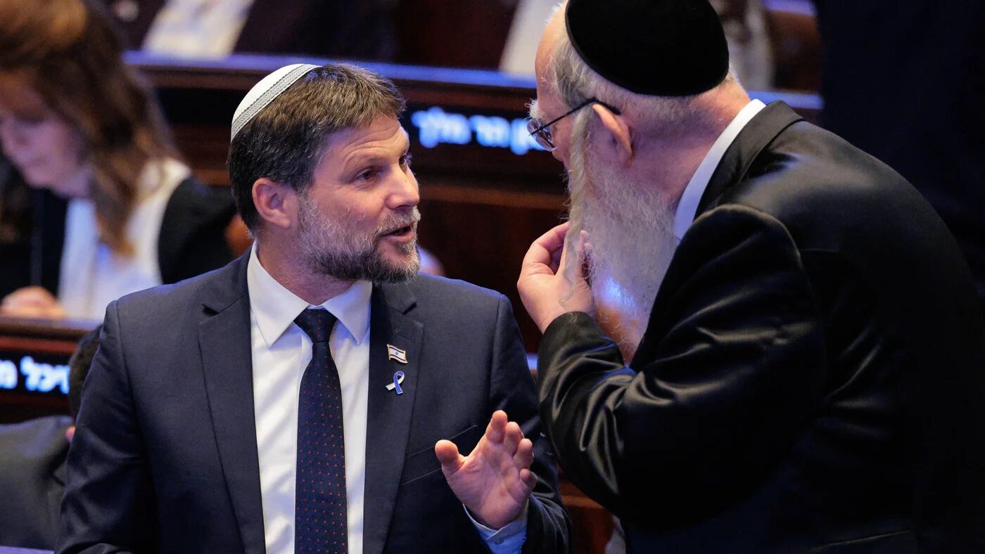 Israel's Finance Minister Bezalel Smotrich (L) stands at the Israeli parliament, the Knesset, on 13 October 2025 (AFP/Pool/Chip Somodevilla)