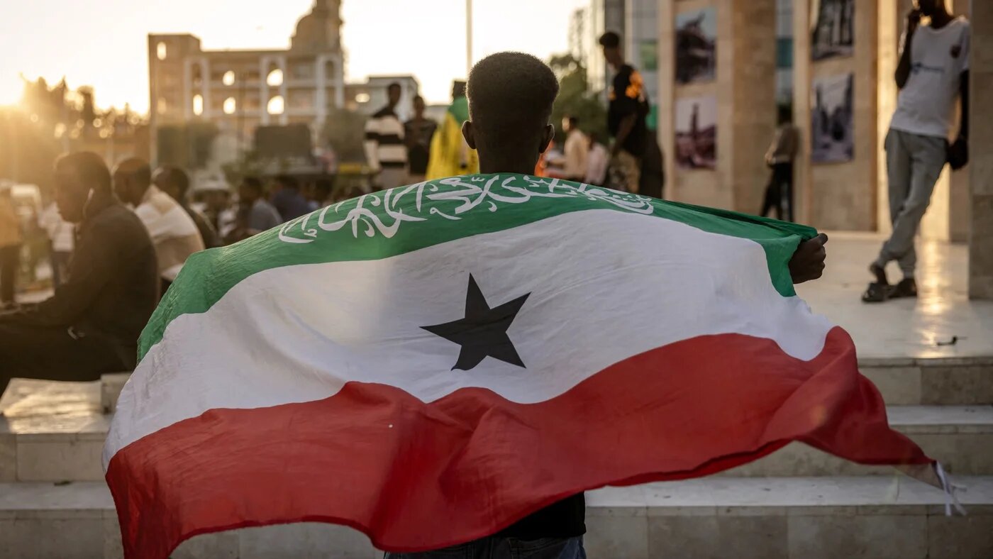 A man holds a flag of Somaliland in front of the Hargeisa War Memorial monument in Hargeisa on 7 November 2024 (Luis Tato/AFP)