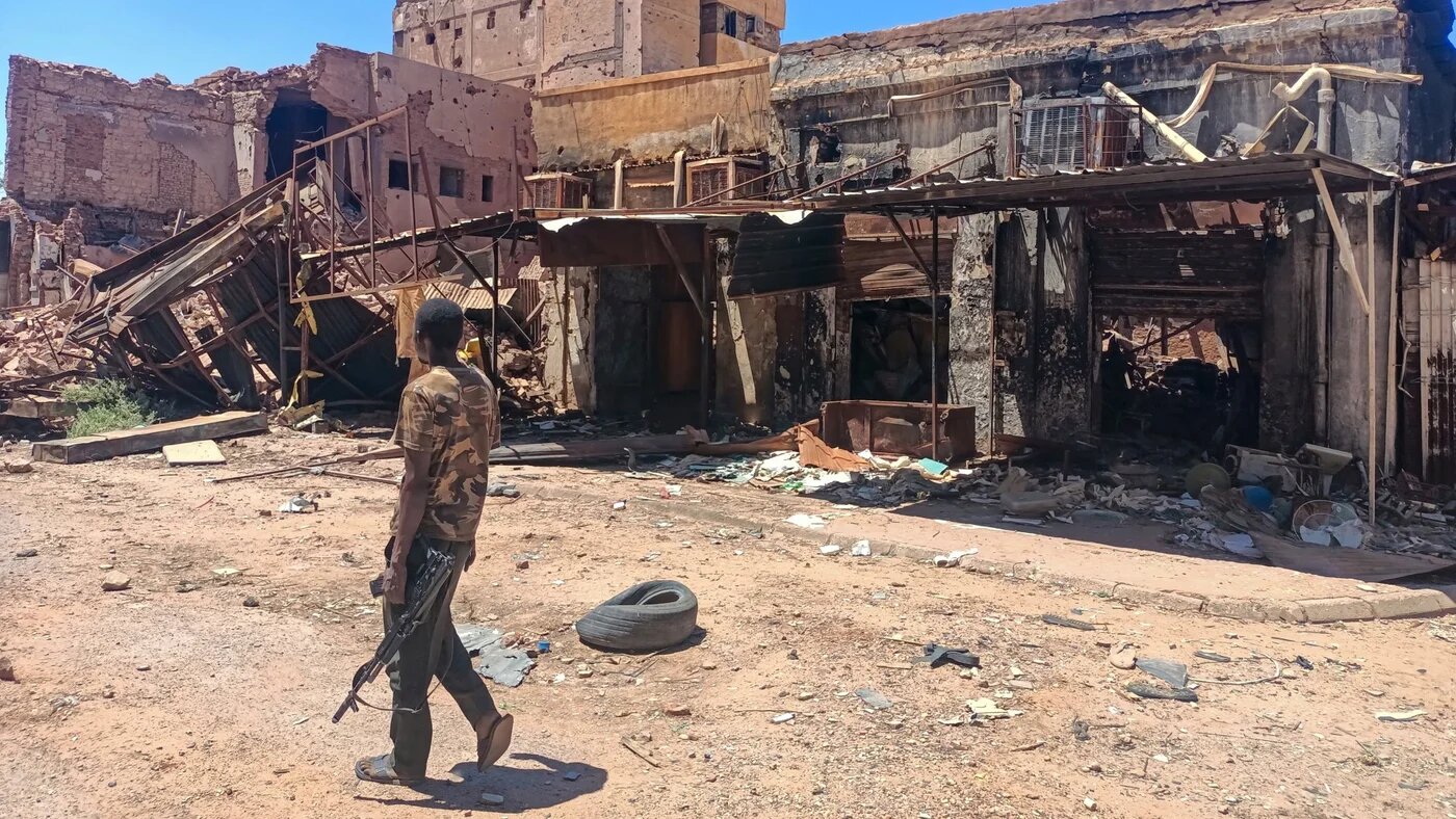 A fighter loyal to Sudan's army patrols a market area in Khartoum on 24 March 2025 (AFP)