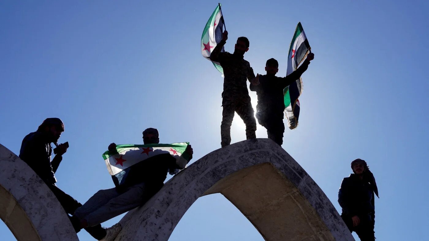 People hold flags as they celebrate, after Syria and the SDF struck a deal to bring Kurdish civilian and military authorities under central government control on 19 January 2026 (Reuters/Karam al-Masri)