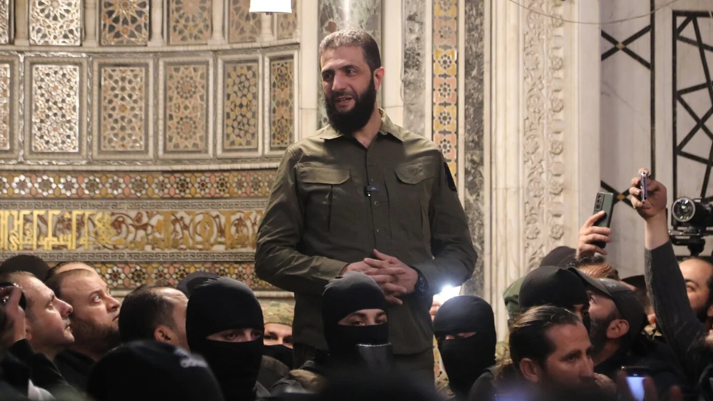 The leader of Syria's Hay'at Tahrir al-Sham (HTS) group, Abu Mohammed al-Jolani, addresses a crowd in Damascus' landmark Umayyad Mosque on 8 December, 2024 (Abdulaziz Ketaz/AFP)