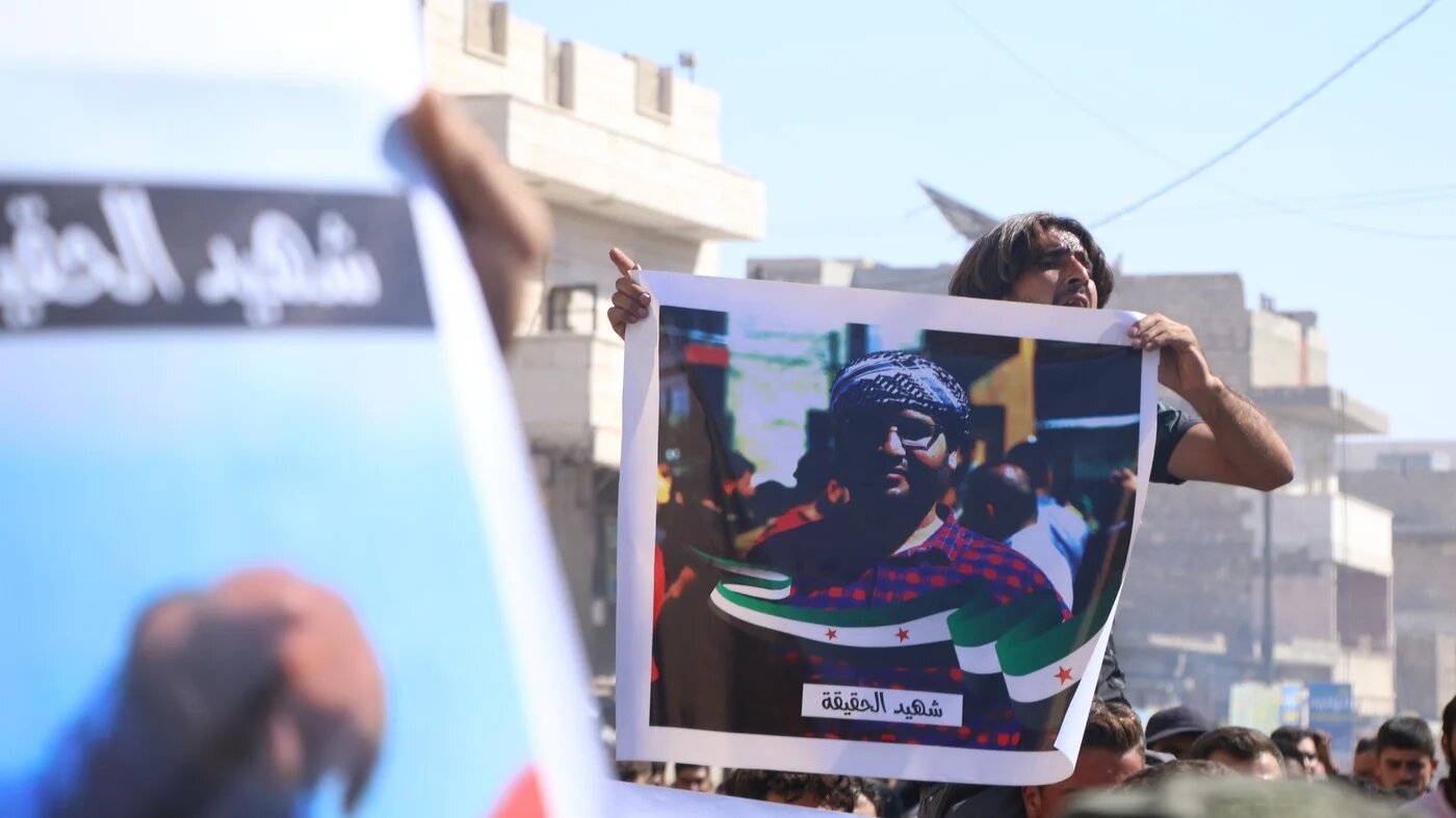Photo of Syrian activist Muhammad Abdul Latif, who was killed by unknown assailants in al-Bab city, held by mourners during his funeral on 8 October 2022 (MEE/Walid al-Idlibi)