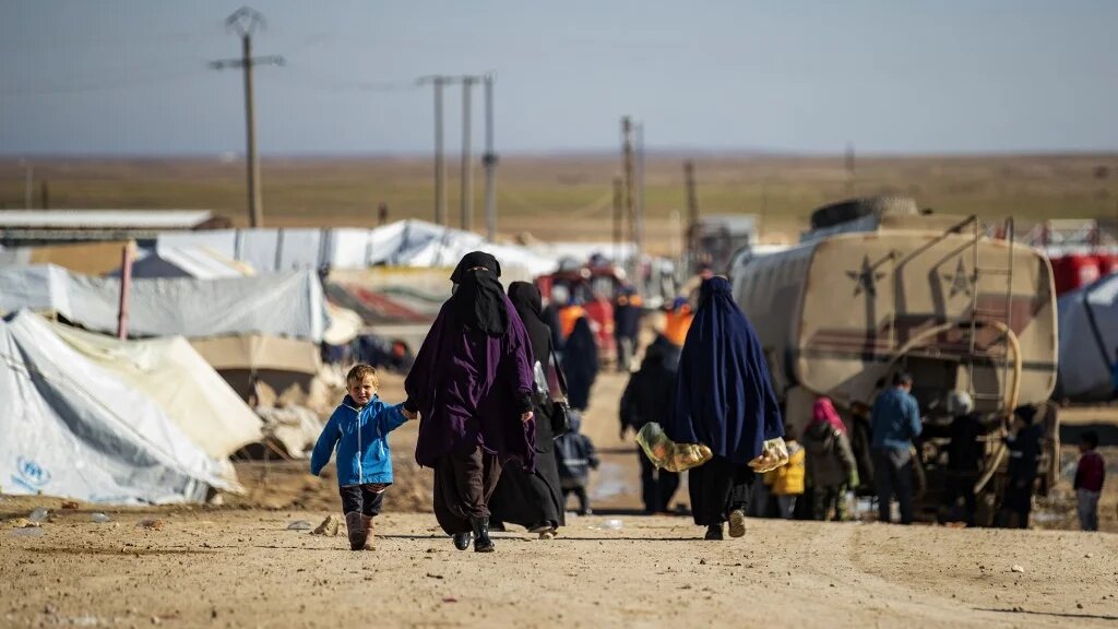 Women walk by with children in a main alley of the Kurdish-run al-Hol camp in Syria in January.