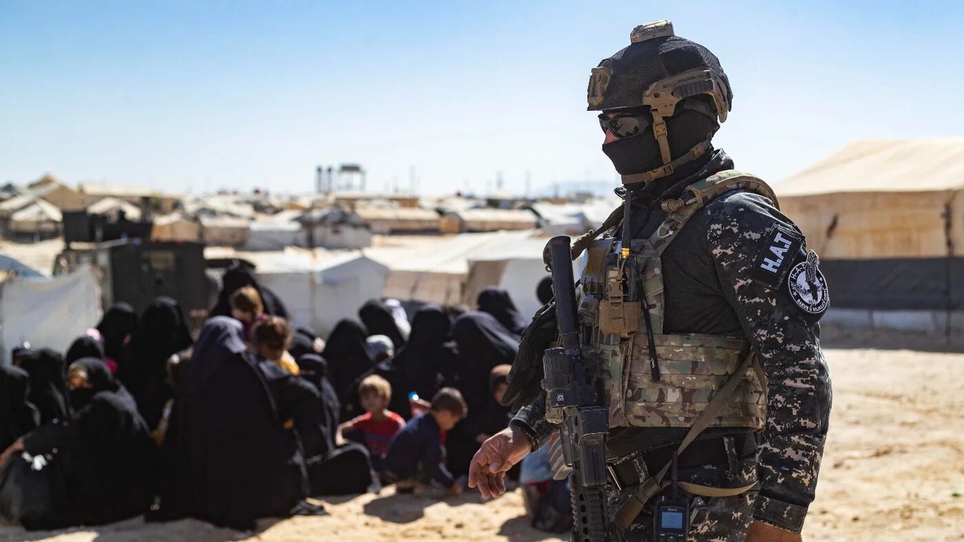 A member of the Syrian Kurdish Asayish security forces stands guard during an inspection of tents at the Kurdish-run al-Hol camp on 28 August 2022.