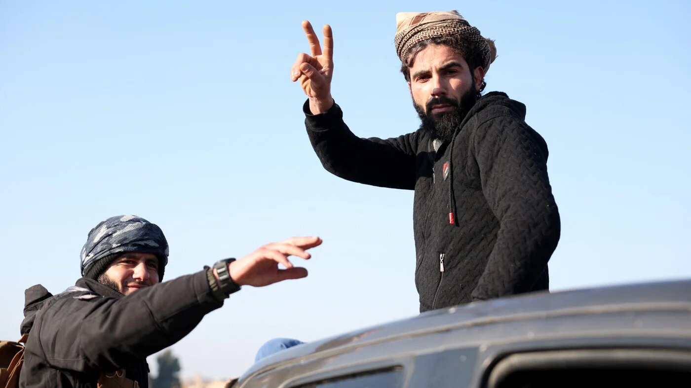 Syrian government forces gesture as they deploy after crossing the Euphrates River in the province of Deir Ezzor, eastern Syria on January 19, 2026 (AFP)