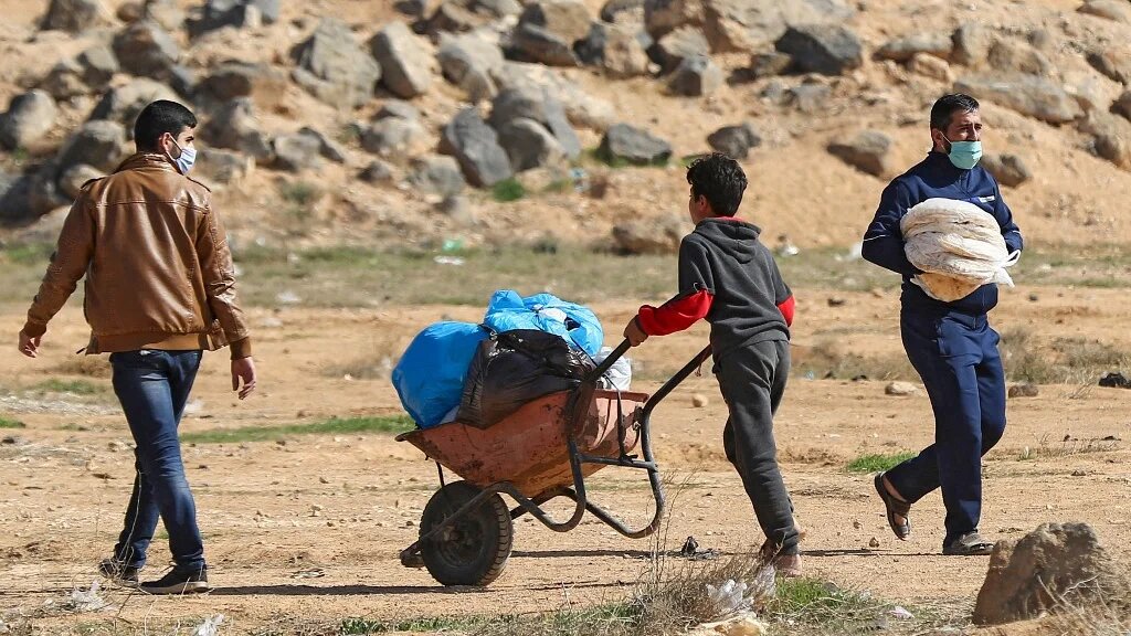 A Syrian refugee pushes a wheelbarrow at the Zaatari refugee camp, 80 kilometers (50 miles) north of the Jordanian capital Amman on 15 February 2021.