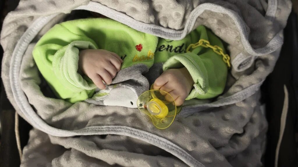 Un bébé dans un berceau dans la « Maison de l’enfant », le principal orphelinat d’Idleb, le 30 avril 2023 (AFP/Omar Hajj Kaddour)