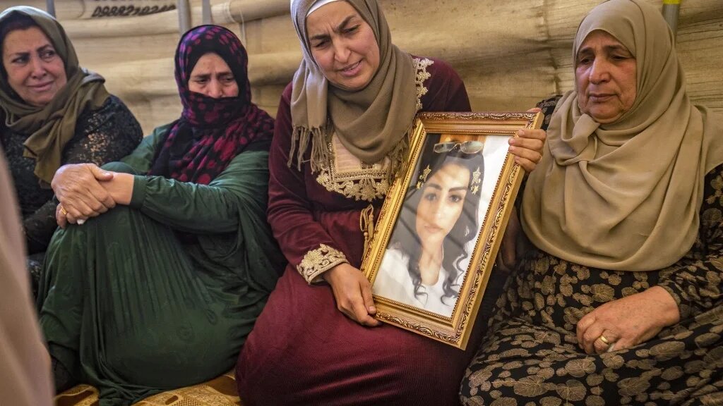 Hiam Saadoun montre la photo de sa fille, Inas, disparue en mer, lors de funérailles à Qamichli, dans le nord-est de la Syrie (AFP/Delil Souleiman)