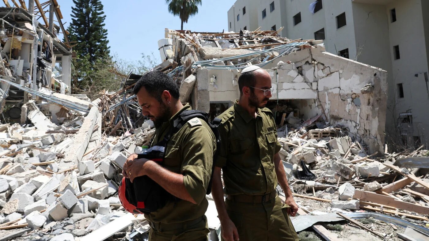 Members of Israeli forces work at an impact site following a missile attack from Iran on Israel in Tel Aviv, 22 June 2025 (Reuters)
