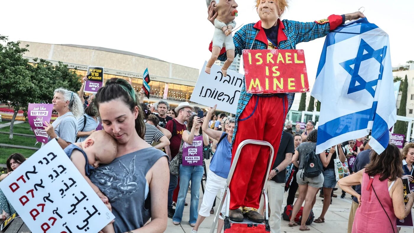 A demonstrator dressed as Donald Trump holds a puppet depicting Benjamin Netanyahu in Tel Aviv last week, in protest at recent violent attacks on Palestinians by Israeli settlers in the West Bank (AFP)
