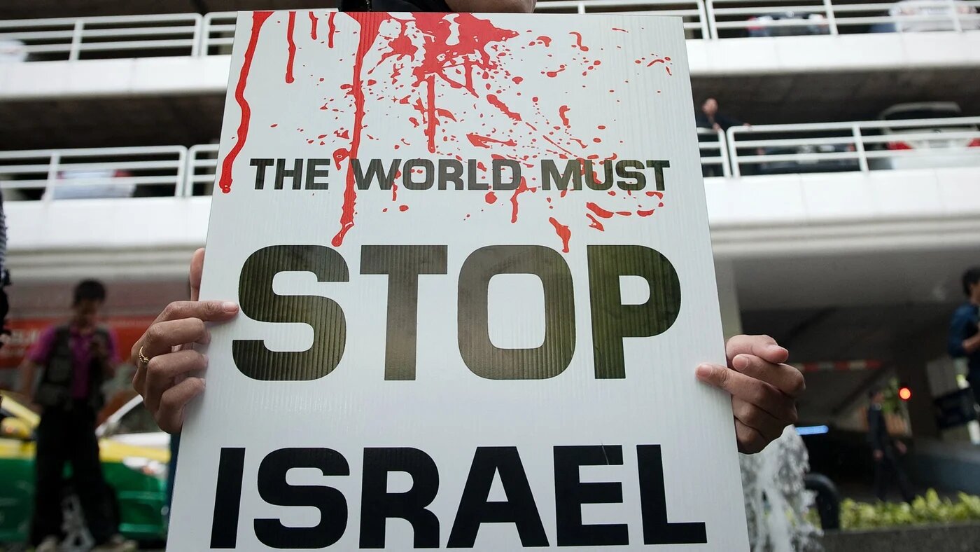 A protester holds a placard outside the Israeli embassy in Bangkok, Thailand, during a demonstration against a previous Israeli war on Gaza in July 2014 (Nicolas Asfouri/AFP)