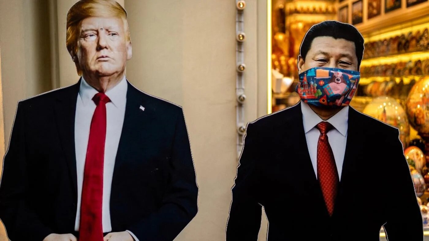Des silhouettes en carton du président chinois Xi Jinping et du président américain Donald Trump devant une échoppe de souvenirs à Moscou, le 3 juin (AFP)
