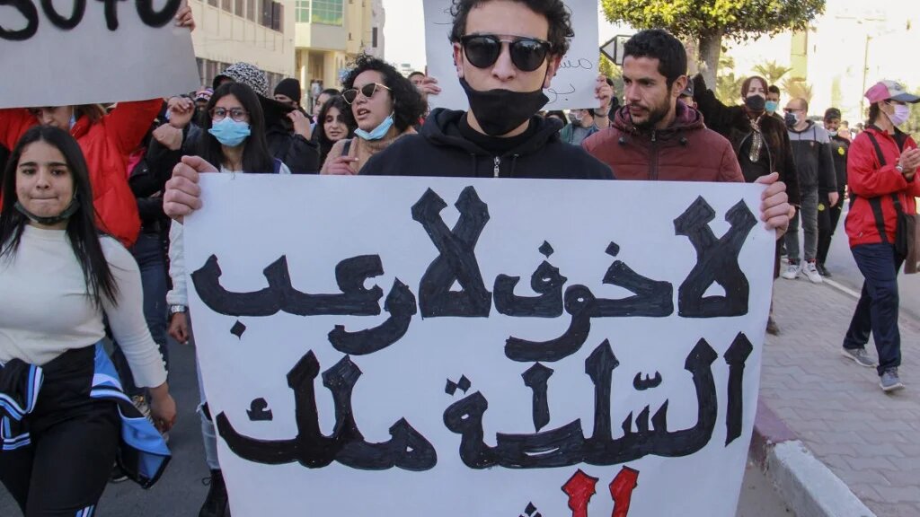 Tunisian protesters lift placards and chant during an anti-government demonstration in the coastal city of Sfax on 19 January 2021.