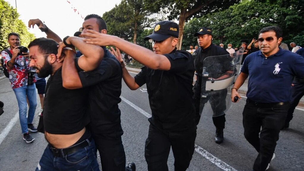 Des policiers tunisiens arrêtent un manifestant le 22 juillet 2022, lors d’une manifestation le long de l’avenue Habib Bourguiba à Tunis, la capitale, contre leur président et le référendum constitutionnel du 25 juillet (AFP/Fethi Belaid)