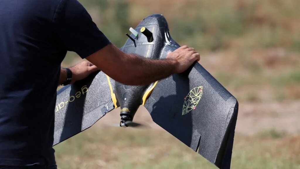 Un technicien de la startup RoboCare s’apprête à survoler un domaine agricole avec un drone, pour scanner les arbres depuis les airs et évaluer leur niveau d’hydratation, la qualité des sols et leur état de santé général, afin de prévenir des dommages irréversibles, dans la région de Nabeul, au sud-ouest de Tunis, le 30 août 2023 (AFP)