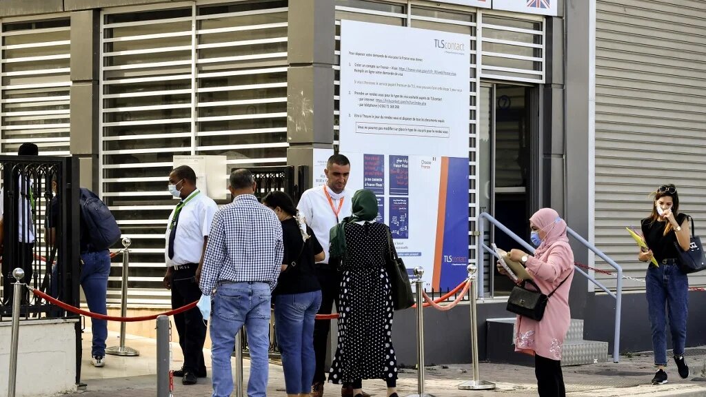 Des Tunisiens font la queue devant les bureaux de TLScontact, une société qui travaille avec les gouvernements du monde entier pour fournir des services de visa, à Tunis, le 29 septembre 2021 (AFP/Fethi Belaïd)