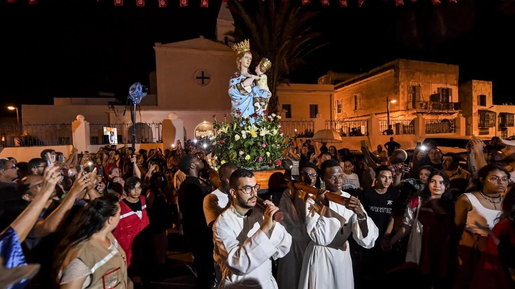 Procession de fidèles portant la « Madone de Trapani » à La Goulette, dans la banlieue de Tunis, le 15 août 2022  (AFP/Fethi Belaid)