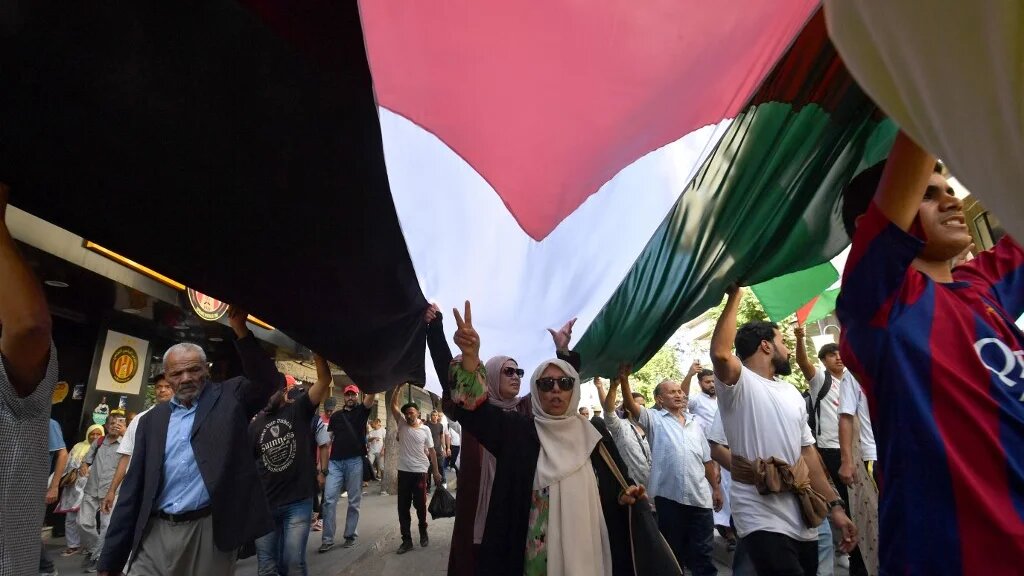 Des Tunisiens manifestent sous un immense drapeau de la Palestine, le 13 octobre à Tunis (AFP/Fethi Belaid)