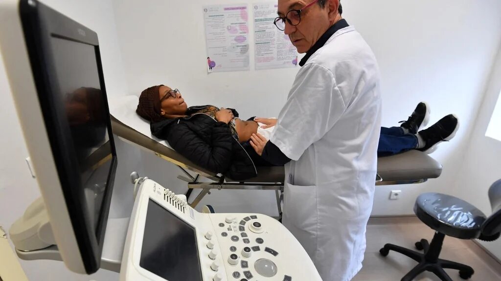 Le médecin tunisien et professeur de gynécologie Fethi Zhiwa, spécialisé dans l’infertilité, examine une patiente dans une clinique de Tunis, le 6 décembre 2023 (AFP/Fethi Belaïd)