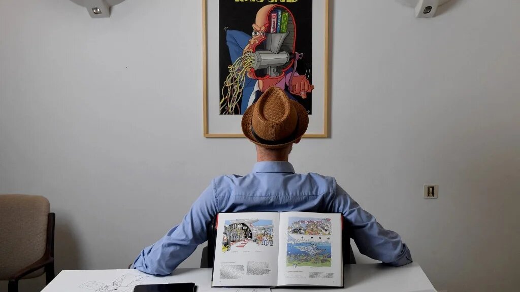 Le dessinateur qui se fait appeler par la seule lettre « Z » a demandé d’apparaître visage caché sur les photos pour conserver un anonymat adopté depuis 2007 sous la dictature de Zine el-Abidine Ben Ali (AFP/Fethi Belaïd)