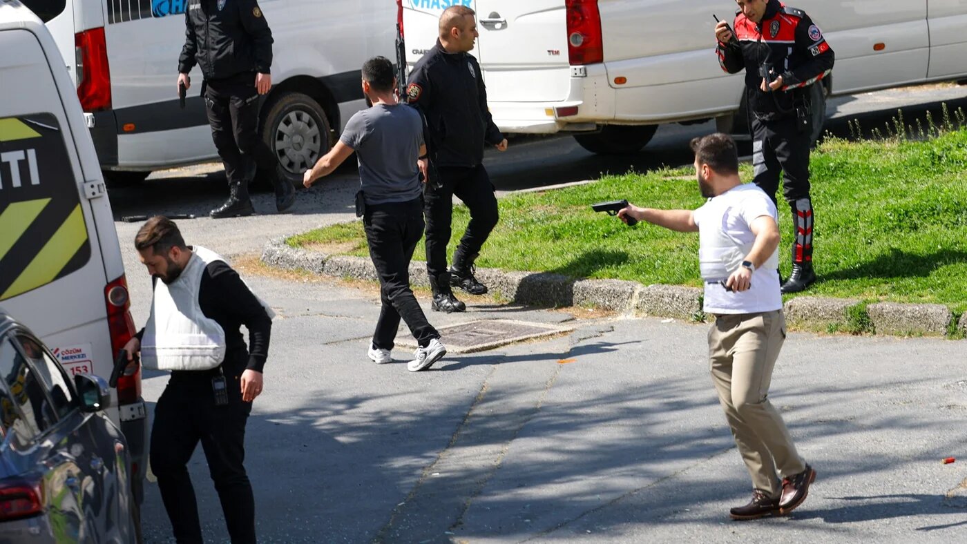 A plainclothes police officer holds a gun, after an attack near the Israeli consulate in Istanbul, Turkey, 7 April 2026 (Reuters/Murad Sezer)
