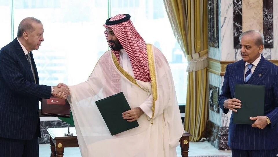 Saudi Crown Prince Mohammed bin Salman (C) signs a joint defence deal with the leaders of Turkey and Pakistan, in Mecca, on 7 August 2026 (Turkish Presidency Press Office/AFP)