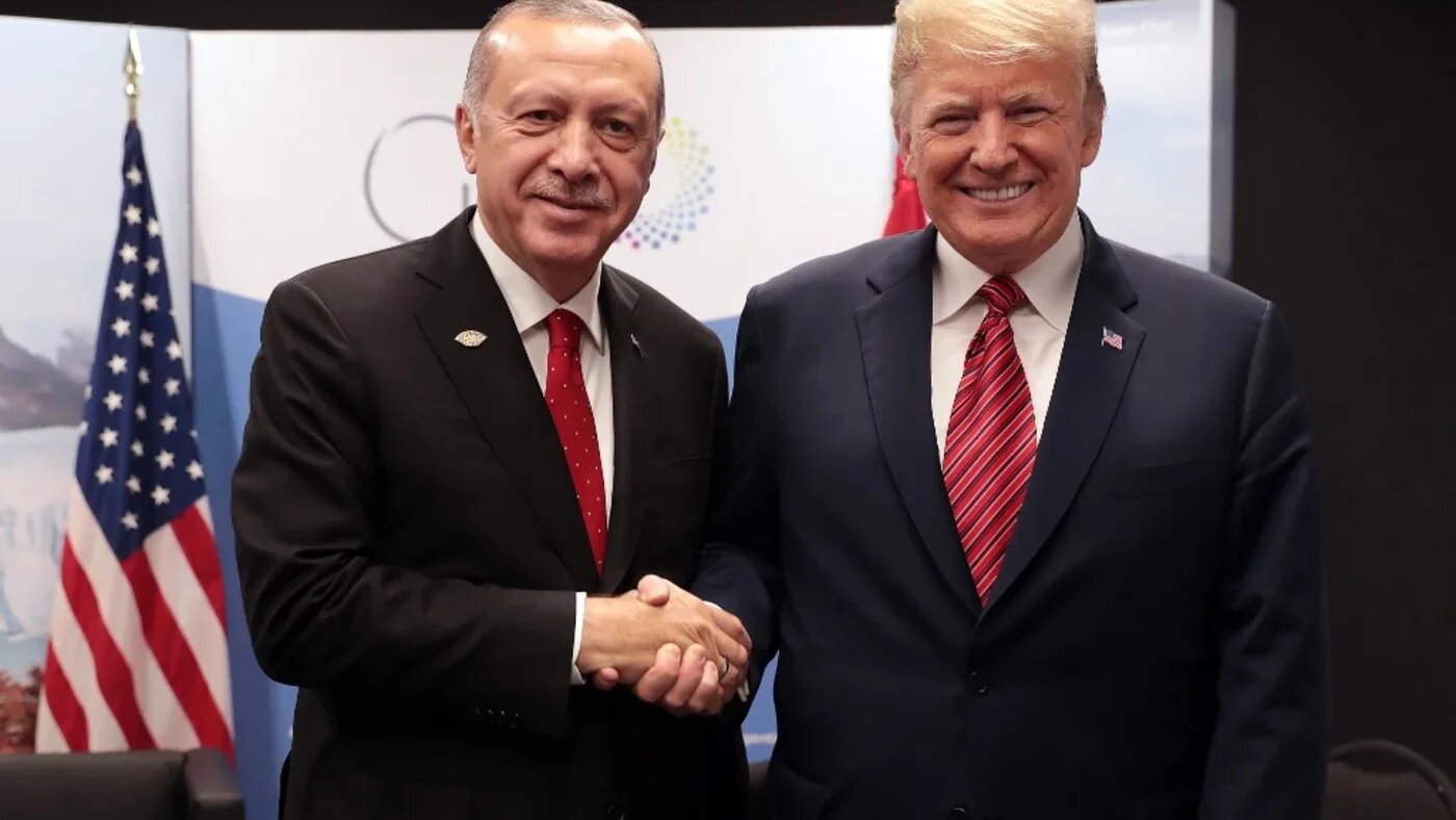 A handout picture released by the Turkish Presidential Palace Press Office shows Turkey's President Recep Tayyip Erdogan (L) posing with US President Donald Trump during the G20 summit in Buenos Aires, Argentina, on 1 December 2018 (AFP)