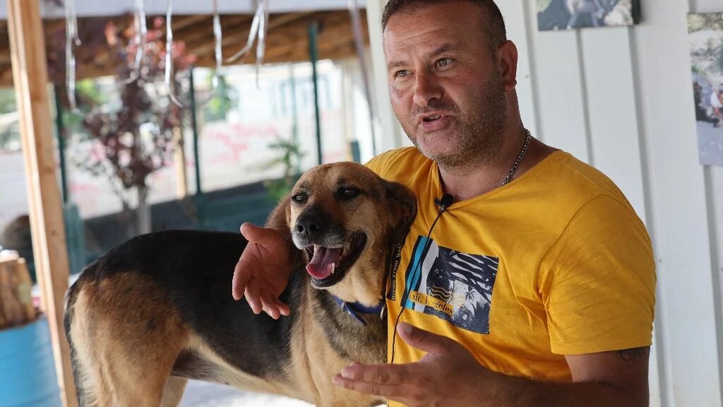 Volkan Koç, fondateur du refuge Patilikoy à Ankara, se tient à côté de Bulut (nuage en turc), l’un des chiens qu’il a sauvés, le 23 août 2022 (AFP/Adem Atlan)