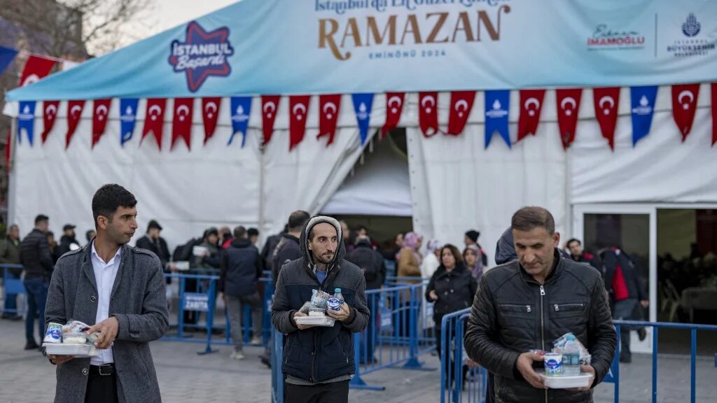 Les fidèles reçoivent des repas pour l’iftar des autorités locales pendant le mois sacré du Ramadan à Istanbul le 15 mars 2024 (AFP/Yasin Akgul)