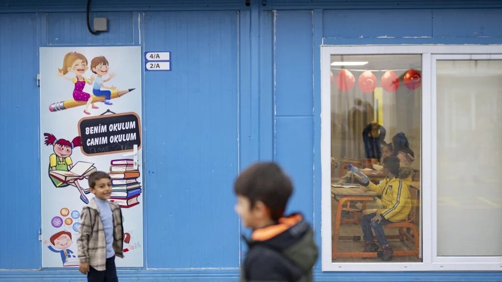 Des enfants reçoivent leurs bulletins scolaires dans une école-conteneur de Kahramanmaraş, le 19 janvier 2024 (AFP/Yasin Akgül)