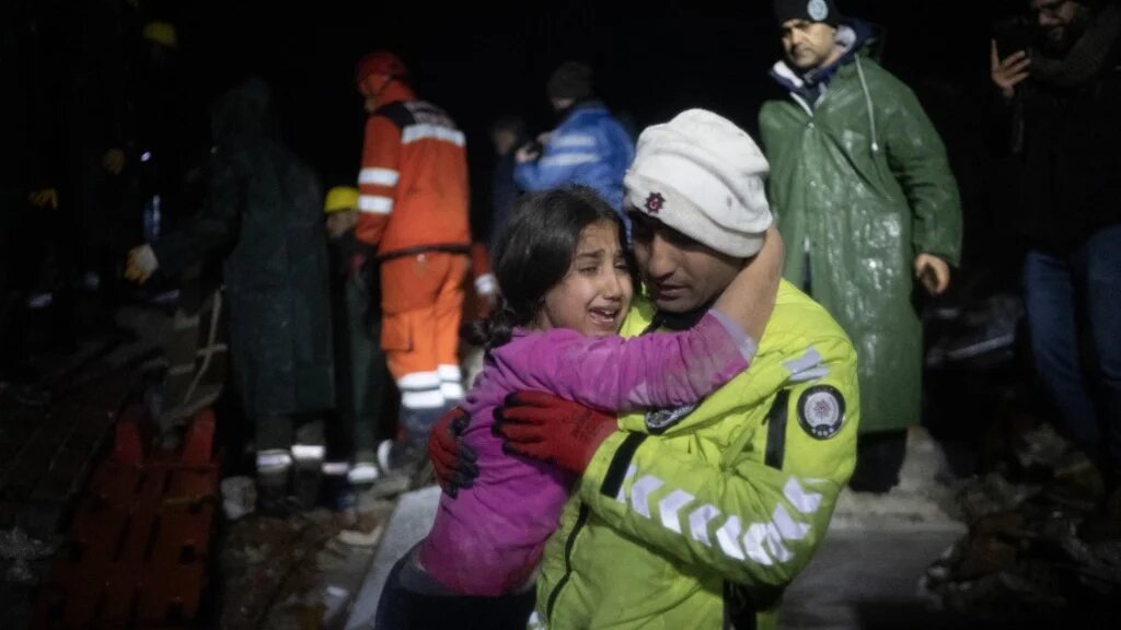 Un officier de police embrasse sa fille après l’avoir sauvée des décombres à Hatay, dans le sud de la Turquie, le 6 février 2023 (AFP/Bulent Kilic)