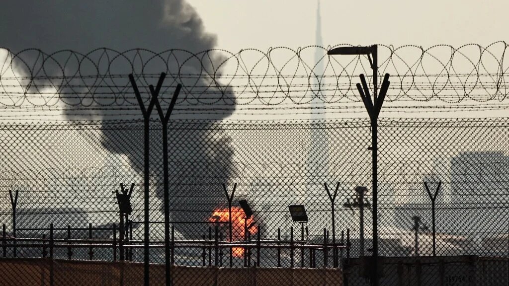 The Dubai skyline is pictured as a smoke plume rises from a fire near the city’s international airport, amid Iranian attacks across the Gulf, on 16 March 2026 (AFP)