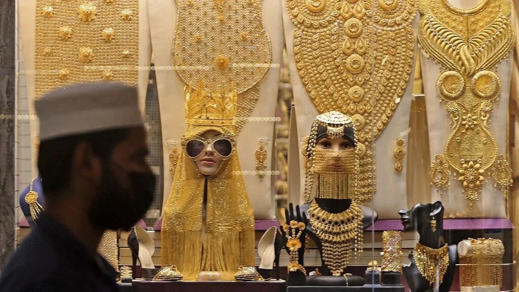 A man walks past a jewellery shop at the gold market in Dubai on 18 August 2021 (AFP)