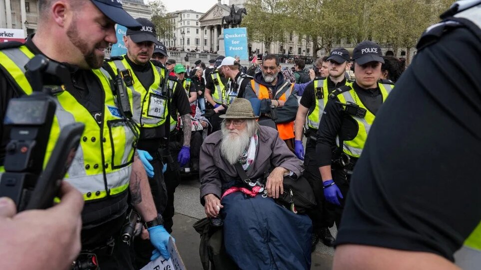 An elderly man in a wheelchair is escorted away by police as protesters gather in support of Palestine Action in central London, on 11 April 2026 (Carlos Jasso/AFP)