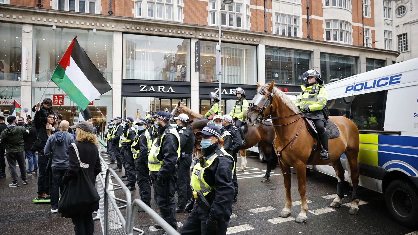 Protester with a Palestinian flag at a police cordon during a protest in central London on 23 May 2021 (AFP/File photo)