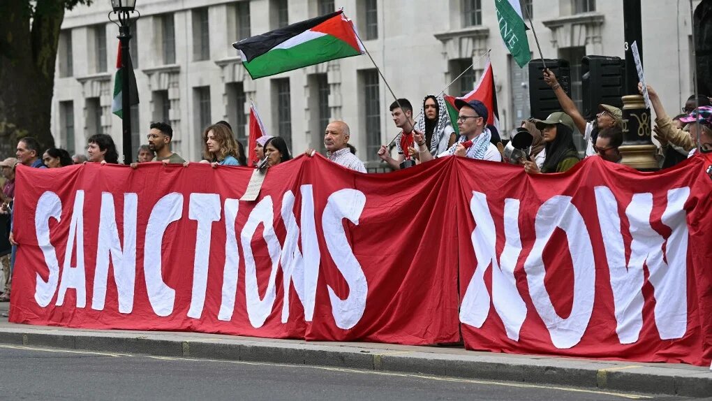Protesters hold a banner calling for sanctions against Israel during a demonstration in support of Palestinians in Gaza, outside Downing Street in London, on 29 July 2025 (Justin Tallis/AFP)