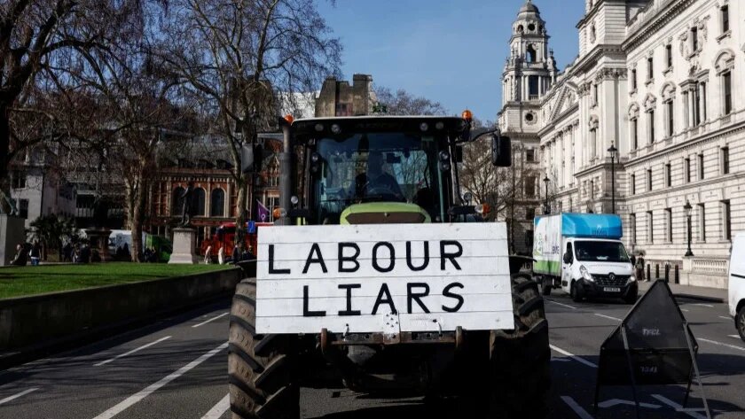 A tractor displaying a protest sign denouncing the governing Labour Party is driven through the streets near Parliament Square in central London on 3 March 2026 (Brook Mitchell/AFP)