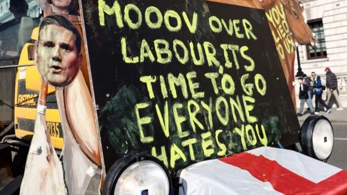 A farm tractor features an image of British Prime Minister Keir Starmer and anti-Labour Party messaging during a protest in London on 3 March 2026 (Brook Mitchell/AFP)