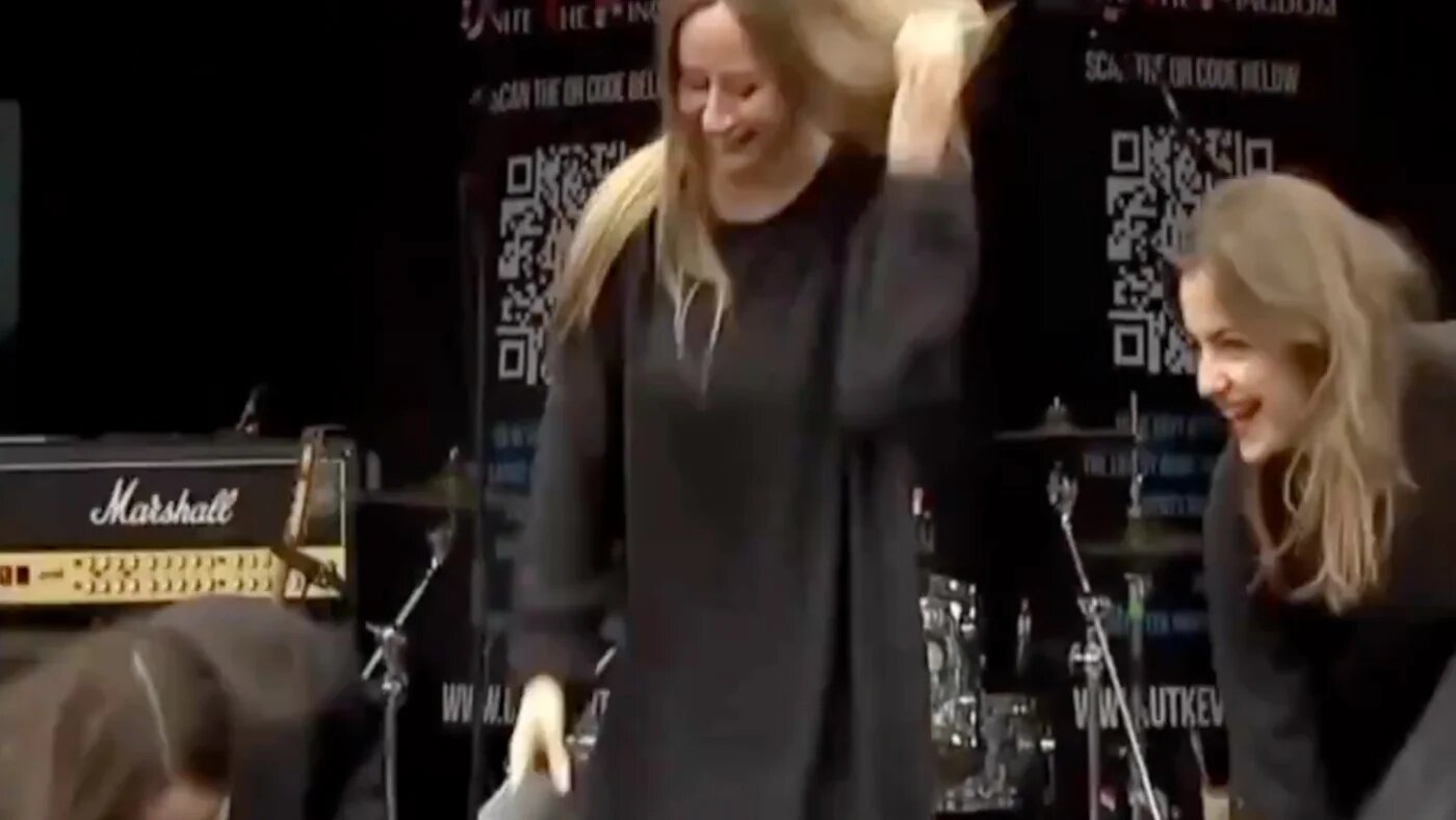 Three women laugh as they remove their niqabs on stage, during the Unite the Kingdom rally in London on 16 May 2026 (Social media screengrab)
