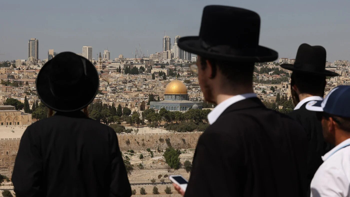 Ultra Orthodox Jewish men stand on Mount of Olives overlooking the Dome of the Rock mosque in Jerusalem's Old City, on September 22, 2025 (AFP/Hazem Bader)