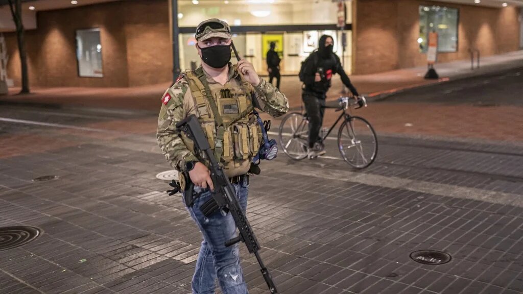 A far-right activist holds an assault rifle during a confrontation with anti-fascists on 8 August 2021 in Portland, Oregon